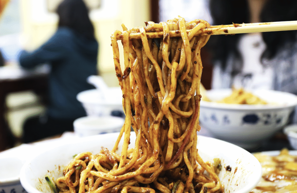 Chinese Glaze on noodles in a bowl with chop sticks