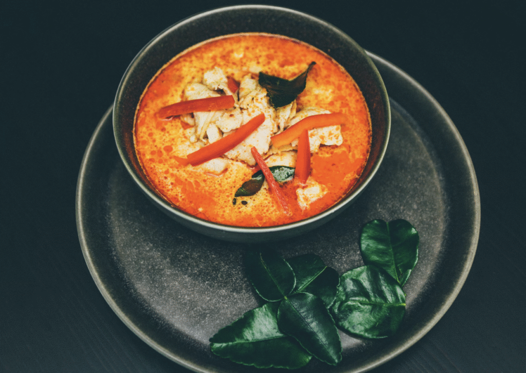Madhuban red thai curry served in a black bowl