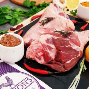 Lamb Shanks on a plate with a mustard sauce and chillis