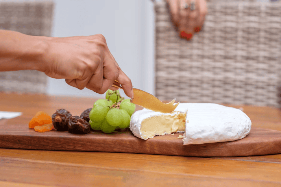 brie on a wooden board with grapes