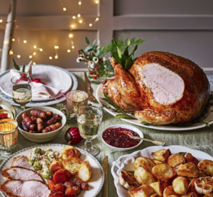large Christmas meal at a dinner table with turkey and vegtables