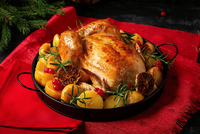 turkey surrounded by vegetables in a dish