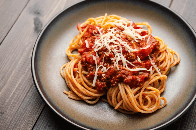 beef mince spaghetti bolognese served onto a plate with cheese